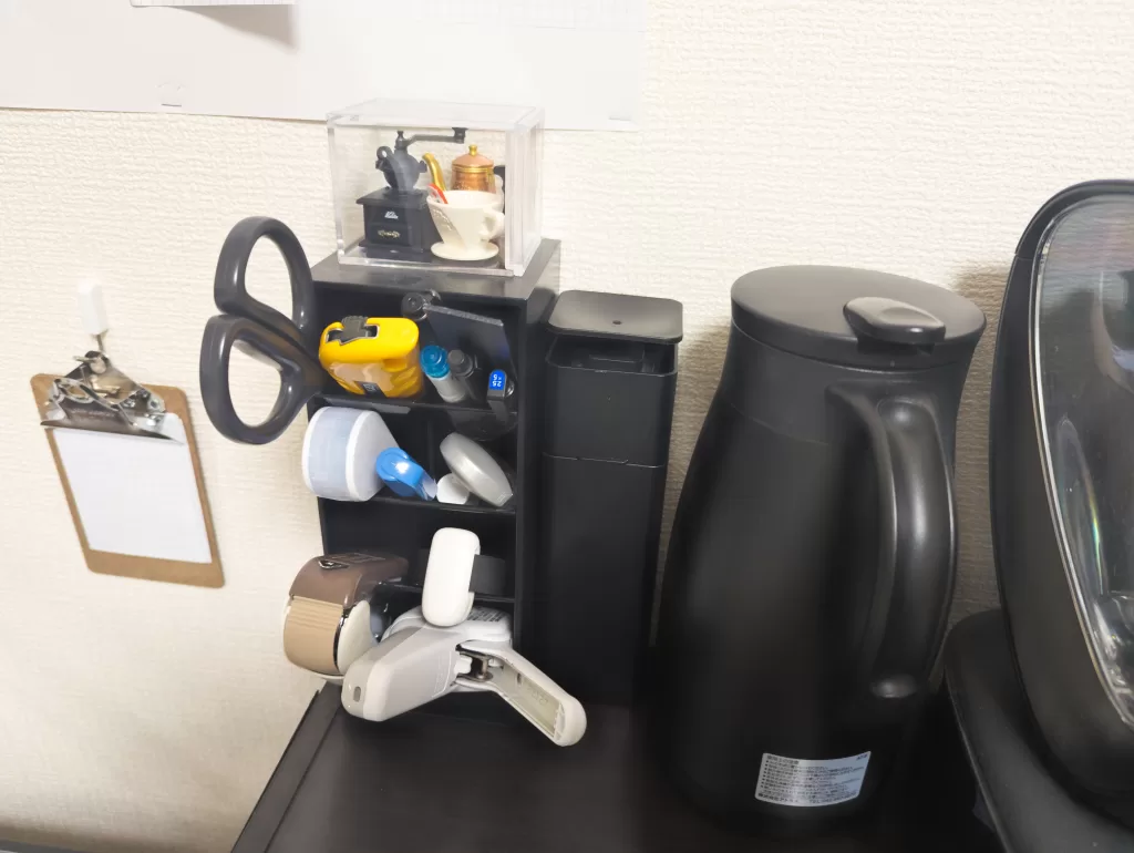 左にはクリップボード、中央にはハサミ、カッター、のり等が入ったペン立てが写された画像